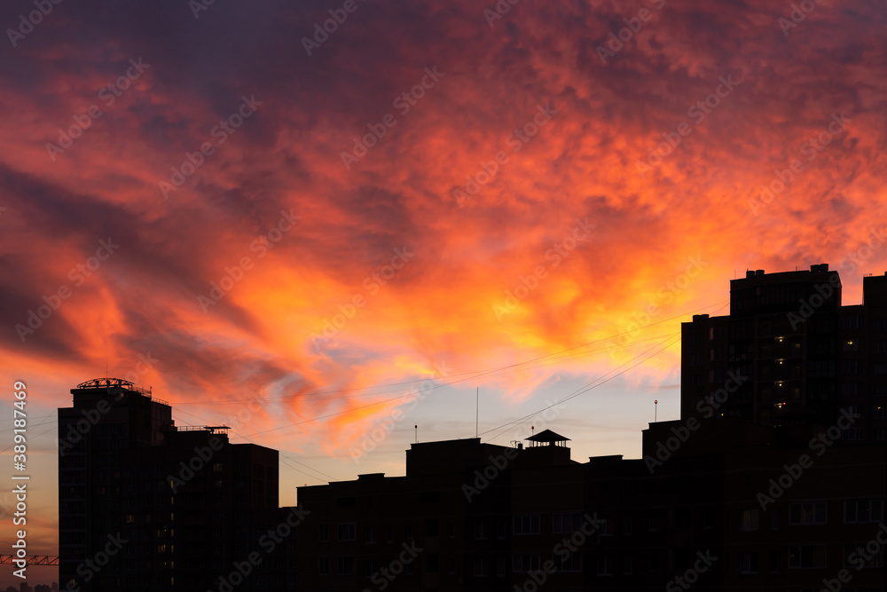 Scenic vivid sunset over city buildings silhouette