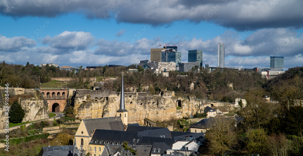 Obraz premium wide horizontal panorama view of Luxembourg City with medieval houses, the fortress wall, and the Kirchberg skyline in the background