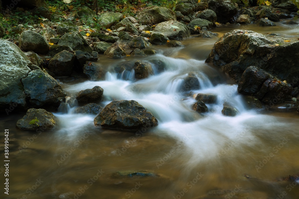The stream of water in the river flowing between the rocks , long exposure photo The stream of water in the river flowing between the rocks , long exposure photo