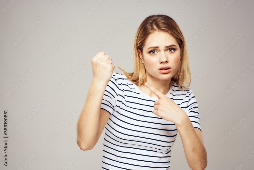 Emotional blonde woman in striped t-shirt lifestyle facial expression close-up