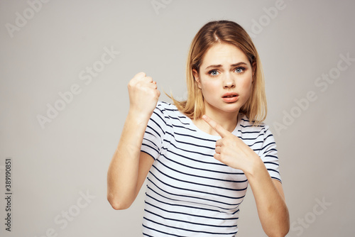 Emotional blonde woman in striped t-shirt lifestyle facial expression close-up