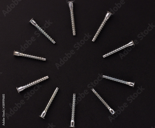 self-tapping screws for furniture assembly, clamping screw, furniture screw on a black background. Background with place for text