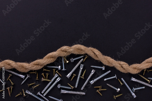 furniture screws, self-tapping screws, rope on a black foil with a place for text