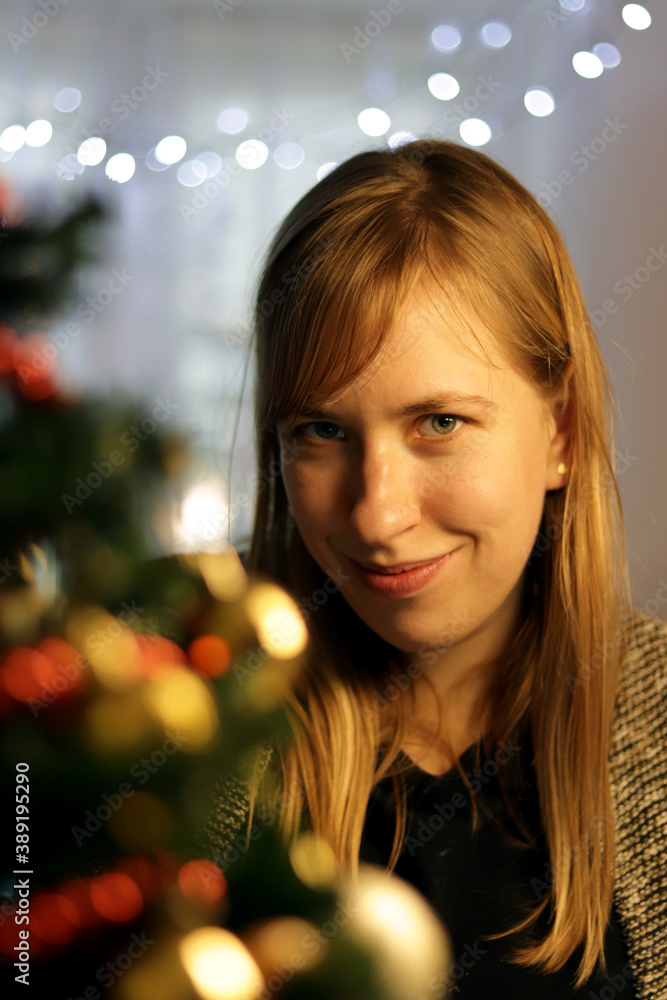 A blonde woman in a Christmas environment looking at the camera A blonde woman in a Christmas environment looking at the camera