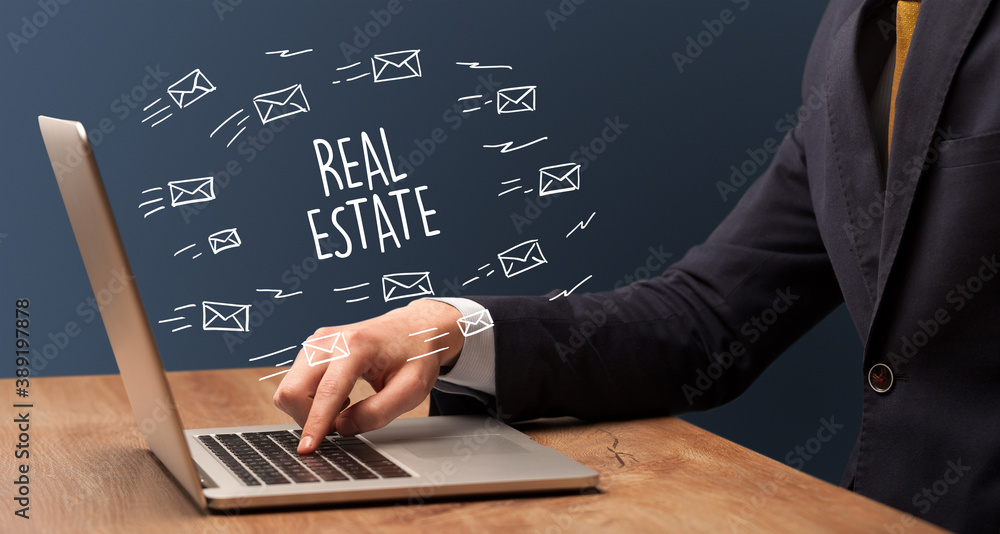 Businessman working on laptop with REAL ESTATE inscription, online shopping concept Businessman working on laptop with REAL ESTATE inscription, online shopping concept