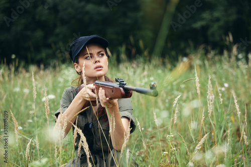 Woman Holds a weapon in the hands of shelter in the grass fresh air green leaves 