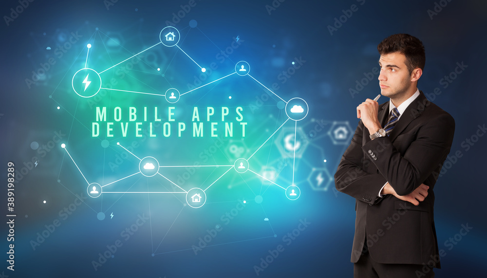 Businessman in front of cloud service icons with MOBILE APPS DEVELOPMENT inscription, modern technology concept Businessman in front of cloud service icons with MOBILE APPS DEVELOPMENT inscription, modern technology concept