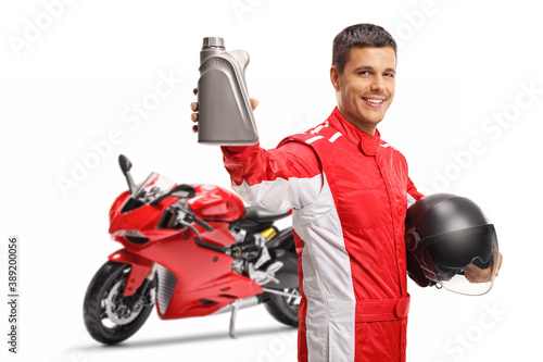 Mortorbike racer showing a bottle of motor oil photo