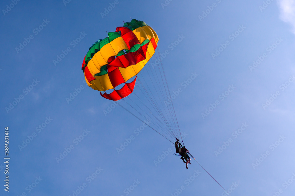 Parasailing in blue sky. Sports, active leisure, travel, vacation concept Parasailing in blue sky. Sports, active leisure, travel, vacation concept