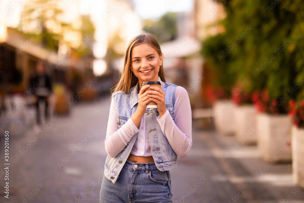 Peaceful woman holding coffee outside on urban background Peaceful woman holding coffee outside on urban background