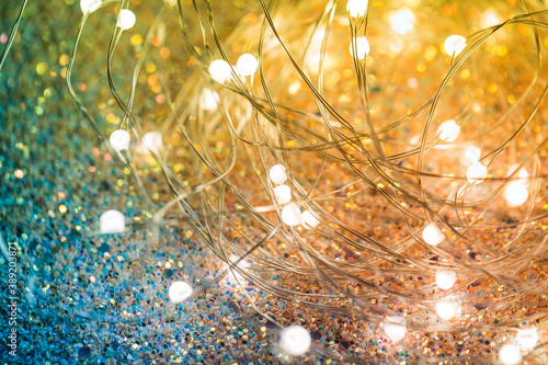 Twinkling Christmas lights on a shiny background. Yellow-green background with LEDs on a wire close-up photo