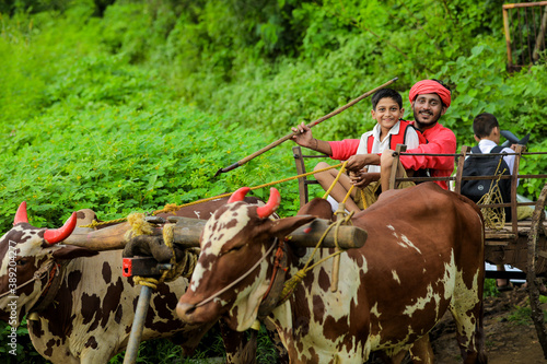 Foto indian farmer and his child going to school on bullock cart