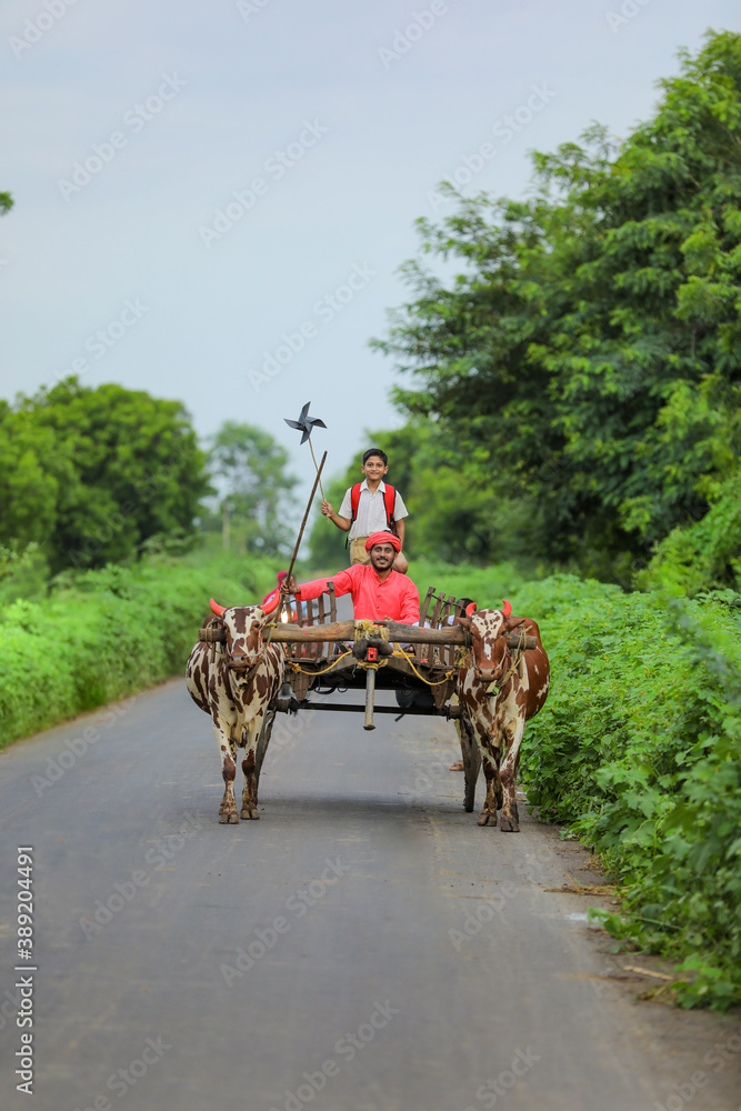 Obraz premium Indian farmer and his child on bullock cart