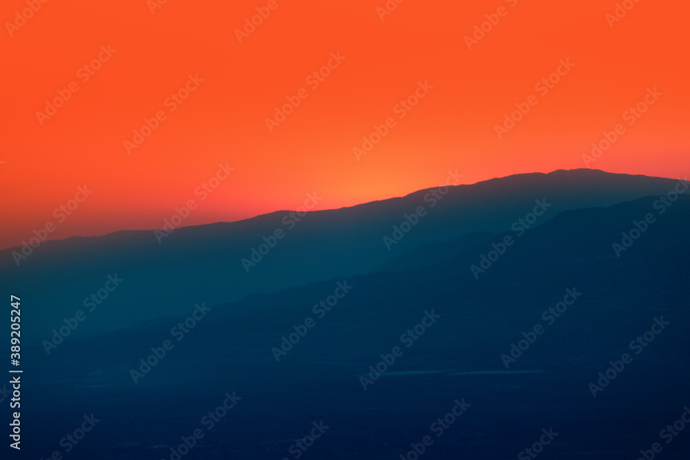 Sun is setting behind big mountain silhoutte
