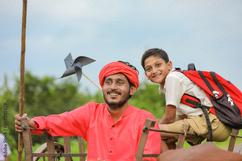 Naklejka premium Indian farmer and his child on bullock cart
