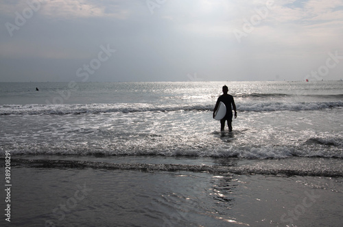 Surfer standing on the beach.