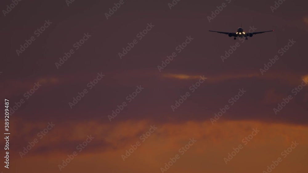 Airliner approaching the airport over ocean in dusky sky. Airliner approaching the airport over ocean in dusky sky.