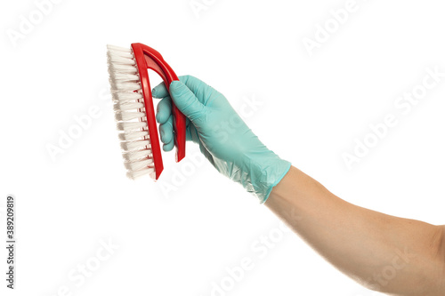 Hand in yellow glove with a red cleaning brush on a white background. Home cleaning concept. photo