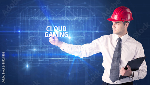 Handsome architect with helmet drawing CLOUD GAMING inscription, new technology concept