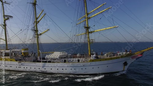 Aerial side view of a navy training ship near the coastline on a sunny day in the Black Sea. Three-masted bark/barque type with square rigging. Romanian flag photo