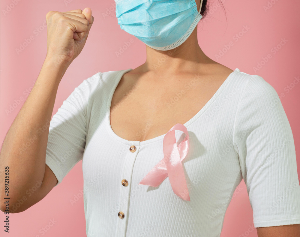 Pink ribbon and protective face mask to support breast cancer. Healthcare and breast cancer awareness concept. Pink ribbon and protective face mask to support breast cancer. Healthcare and breast cancer awareness concept.