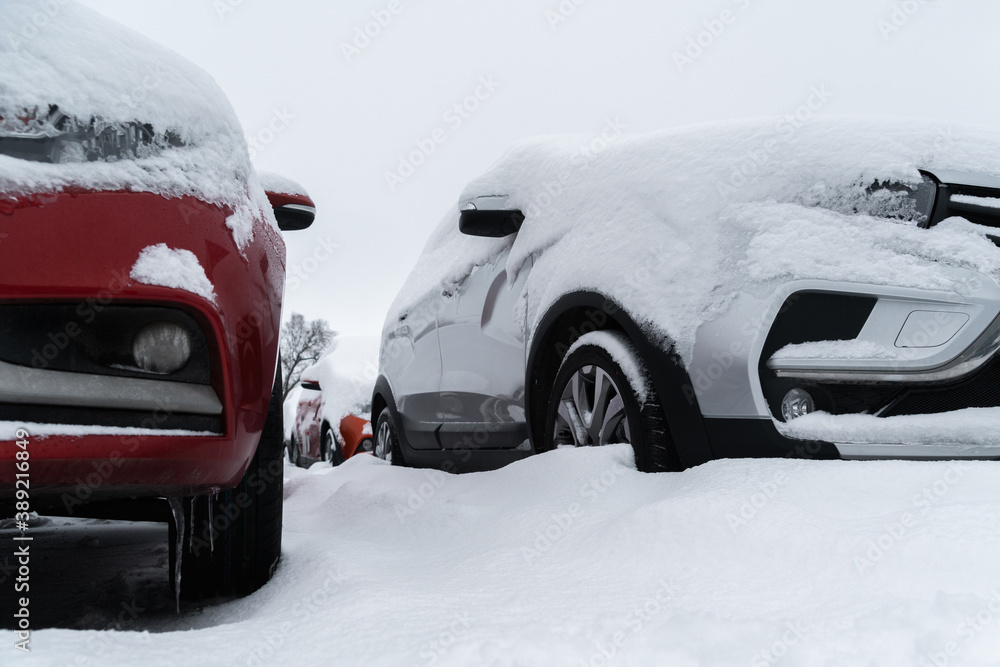 Snow covered parked cars. Winter season	