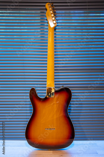 Sunburst electric guitar telecaster shape (gold hardware) on woden table in the room. businoess and music concept. Wallpaper or background photo