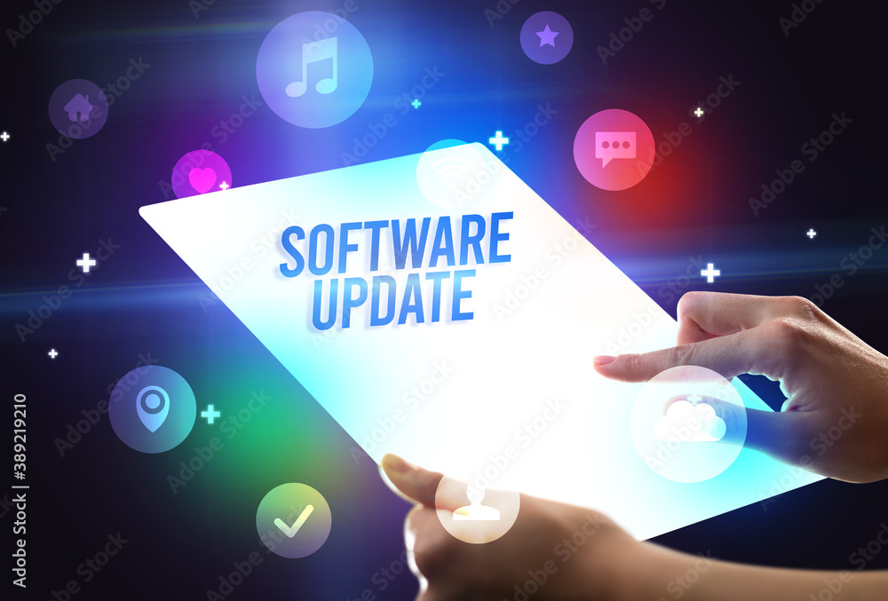 Holding futuristic tablet with SOFTWARE UPDATE inscription, new technology concept Holding futuristic tablet with SOFTWARE UPDATE inscription, new technology concept