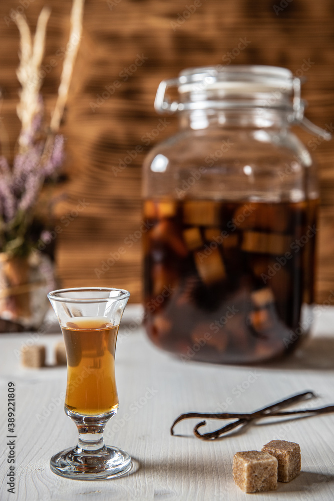 Likör aus Rhabarber, Vanille, Kandiszucker und Schnaps auf weißem Tisch ... Likör aus Rhabarber, Vanille, Kandiszucker und Schnaps auf weißem Tisch ...