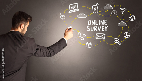 businessman drawing social media icons with ONLINE SURVEY inscription, new media concept