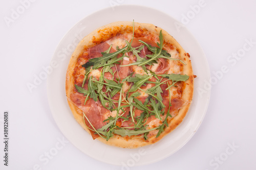 Pizza with prosciutto (parma ham) and arugula (salad rocket)