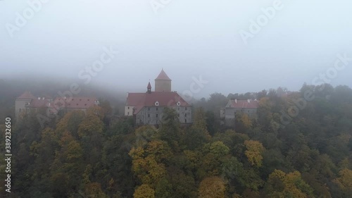 Drone shot of Veveri castle during foggy morning in autumn. Mysterious atmosphere.