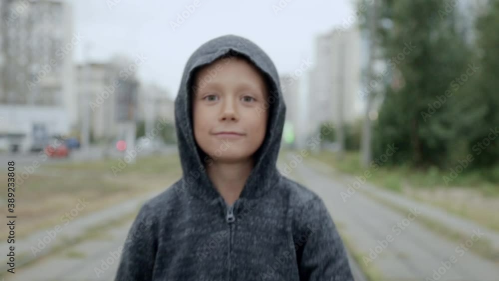 A boy in a black hood on the street A boy in a black hood on the street