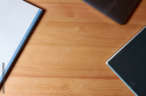 Work table with laptop and notebooks on a wooden base with copy space