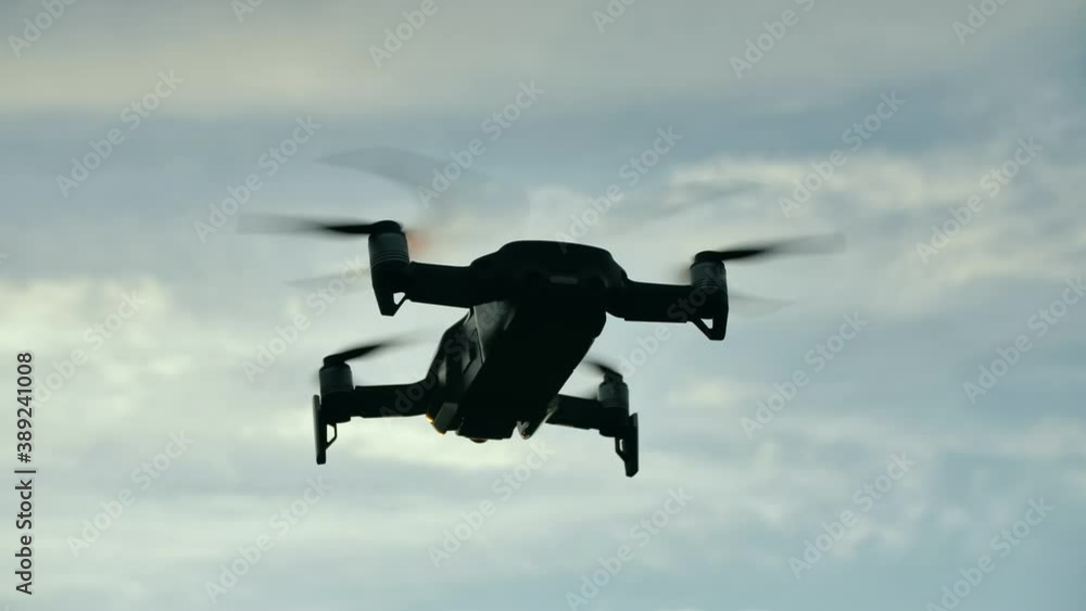The drone hovers in flight at sunset. The drone hovers in flight at sunset.