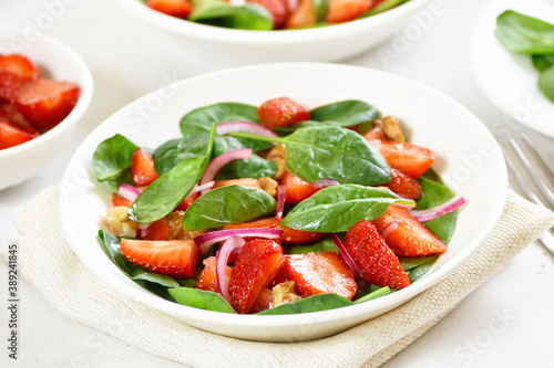 Healthy breakfast with fruit salad from strawberry, spinach and walnut