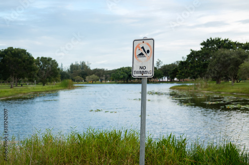horizontal image - no swimming sign in front of a small marsh in Florida park 