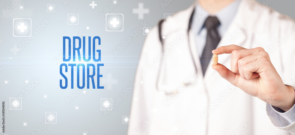 Close-up of a doctor giving a pill with DRUG STORE inscription, medical concept Close-up of a doctor giving a pill with DRUG STORE inscription, medical concept