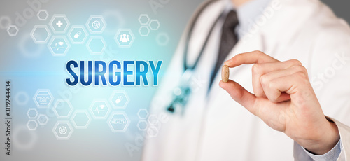 Close-up of a doctor giving you a pill with SURGERY inscription, medical concept