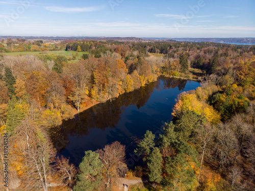 Fototapeta Naklejka Na Ścianę i Meble -  Aerial view of a lake in autumn against a blue sky with clouds