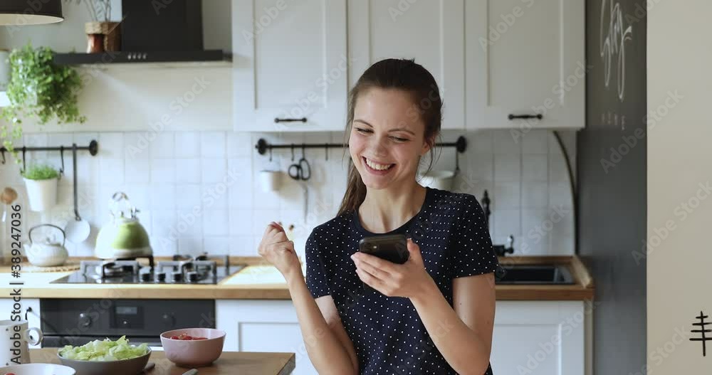 Distracted from cooking young european girl chatting in social network with friends or using dating mobile application, getting invitation on party or celebrating finding good tasty food recipe. Distracted from cooking young european girl chatting in social network with friends or using dating mobile application, getting invitation on party or celebrating finding good tasty food recipe.