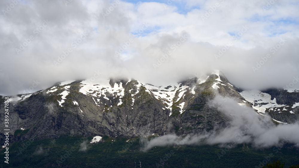 Fototapeta premium Snow covered, cloudy mountain peaks close to Voss, Norway