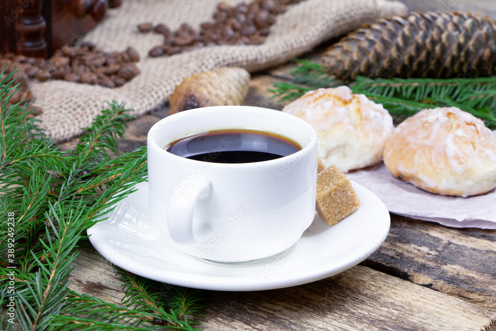 A cup of coffee and cake on a wooden background. Green fir branch on a wooden table. Cane sugar. A cup of espresso A cup of coffee and cake on a wooden background. Green fir branch on a wooden table. Cane sugar. A cup of espresso