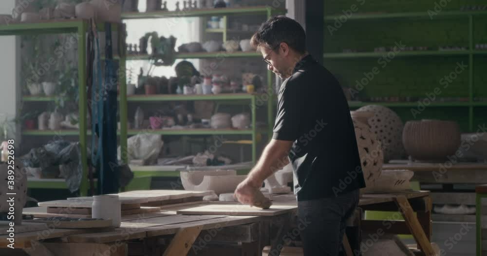 Male ceramist kneading clay in spacious studio Male ceramist kneading clay in spacious studio