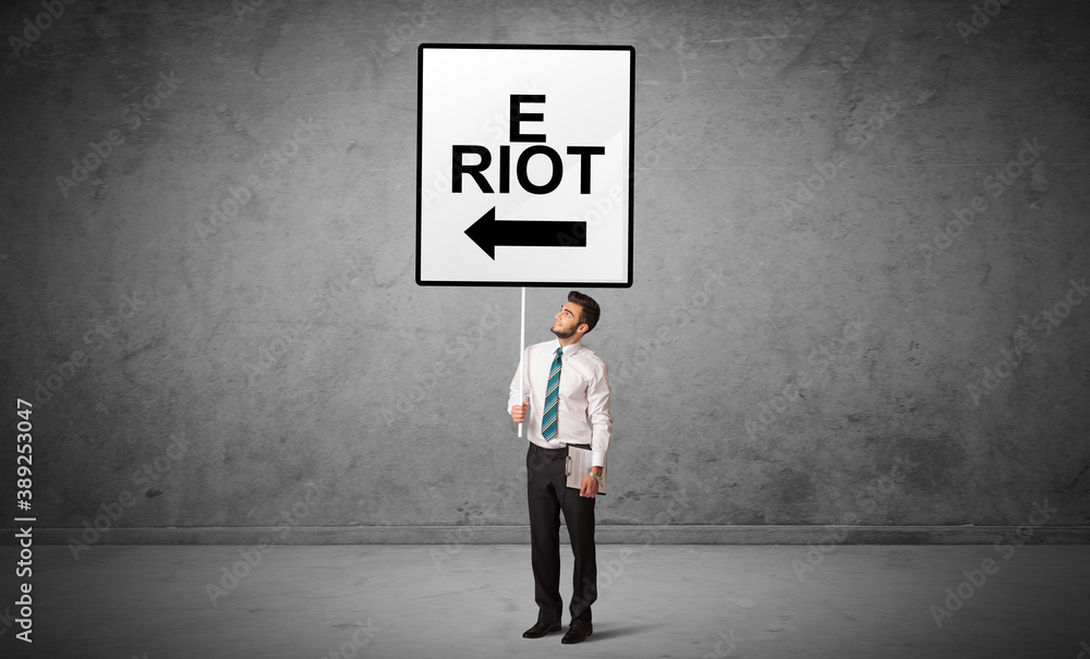 business person holding a traffic sign with E RIOT inscription, new idea concept business person holding a traffic sign with E RIOT inscription, new idea concept