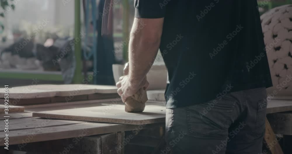 Unrecognizable man softening clay in pottery Unrecognizable man softening clay in pottery