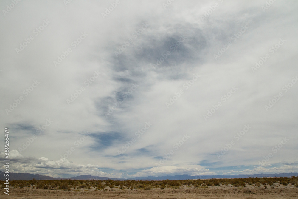 Inspirational nature background for quotes. Beautiful cloudscape. The arid desert sand, horizon and white clouds. 