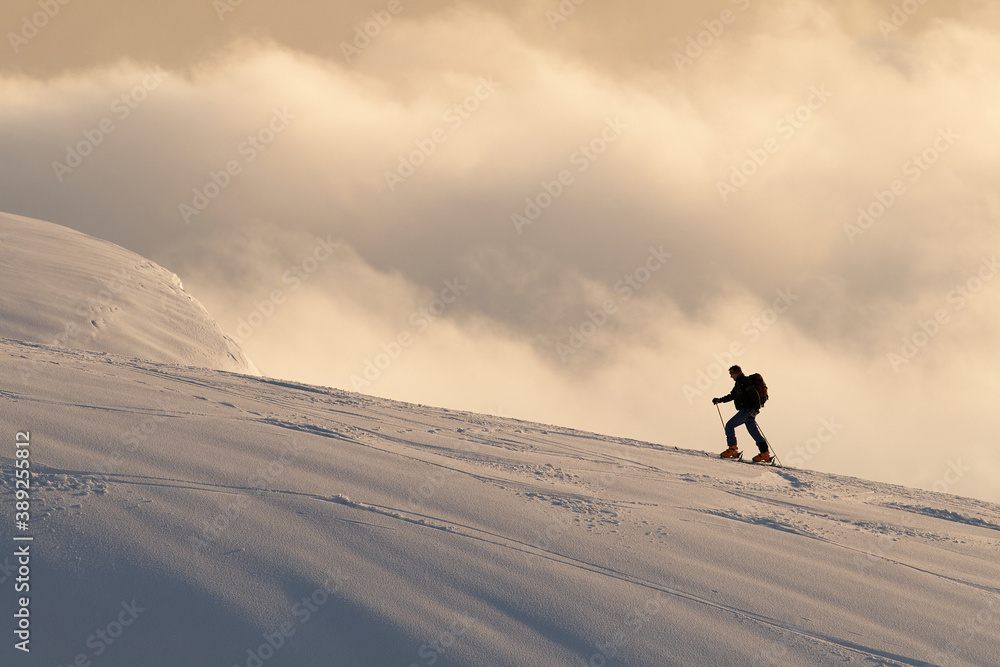 Skier on the top of mountain with clouds