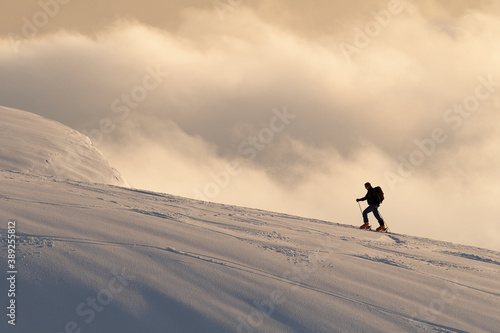 Skier on the top of mountain with clouds