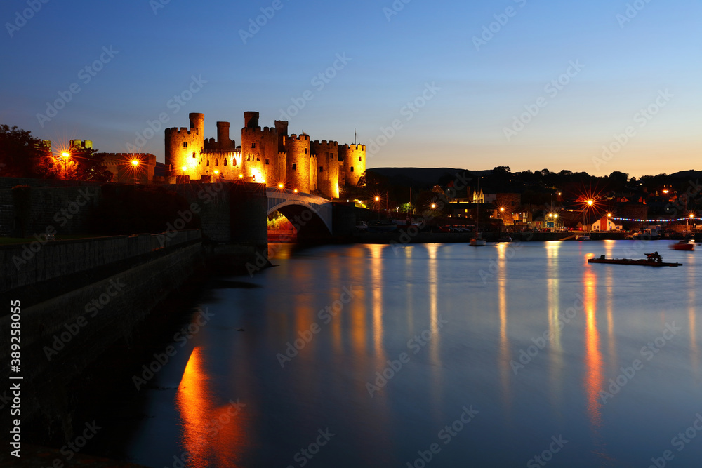 Conwy Castle floodlit against a blue Sky after Sunset, Conwy, North Wales, UK. Conwy Castle floodlit against a blue Sky after Sunset, Conwy, North Wales, UK.